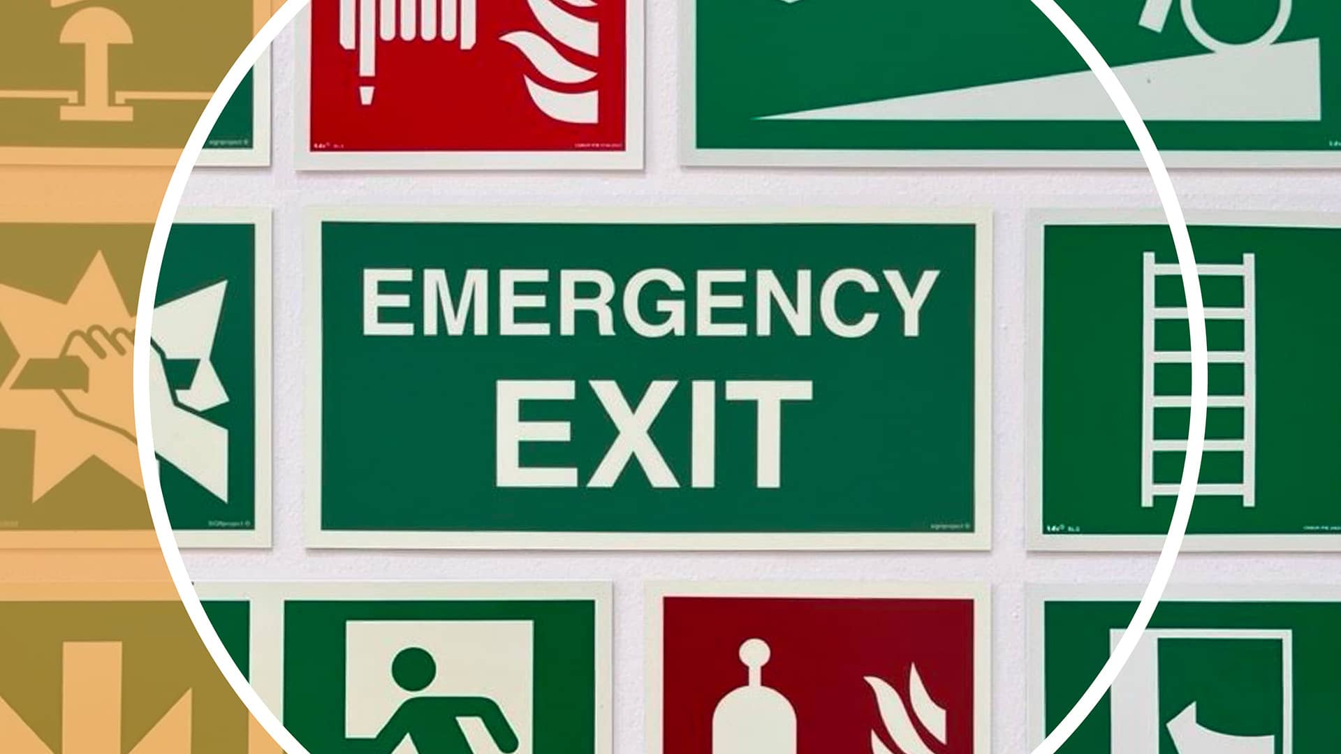 Sammlung von Sicherheitsschildern, darunter ein großes grünes Schild mit der Aufschrift «Emergency Exit», umgeben von Piktogrammen für Fluchtwege, Feuerlöscher und Notausgänge.