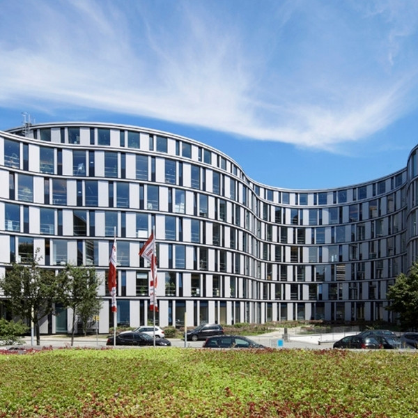 BSI Software Standort in Hamburg – modernes Bürogebäude mit geschwungener Glasfassade und vorgelagerter Grünfläche.