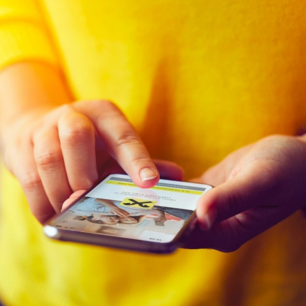 Smartphone with Raiffeisen app in use - BSI Software customer with focus on digital customer experiences and CRM in banking.