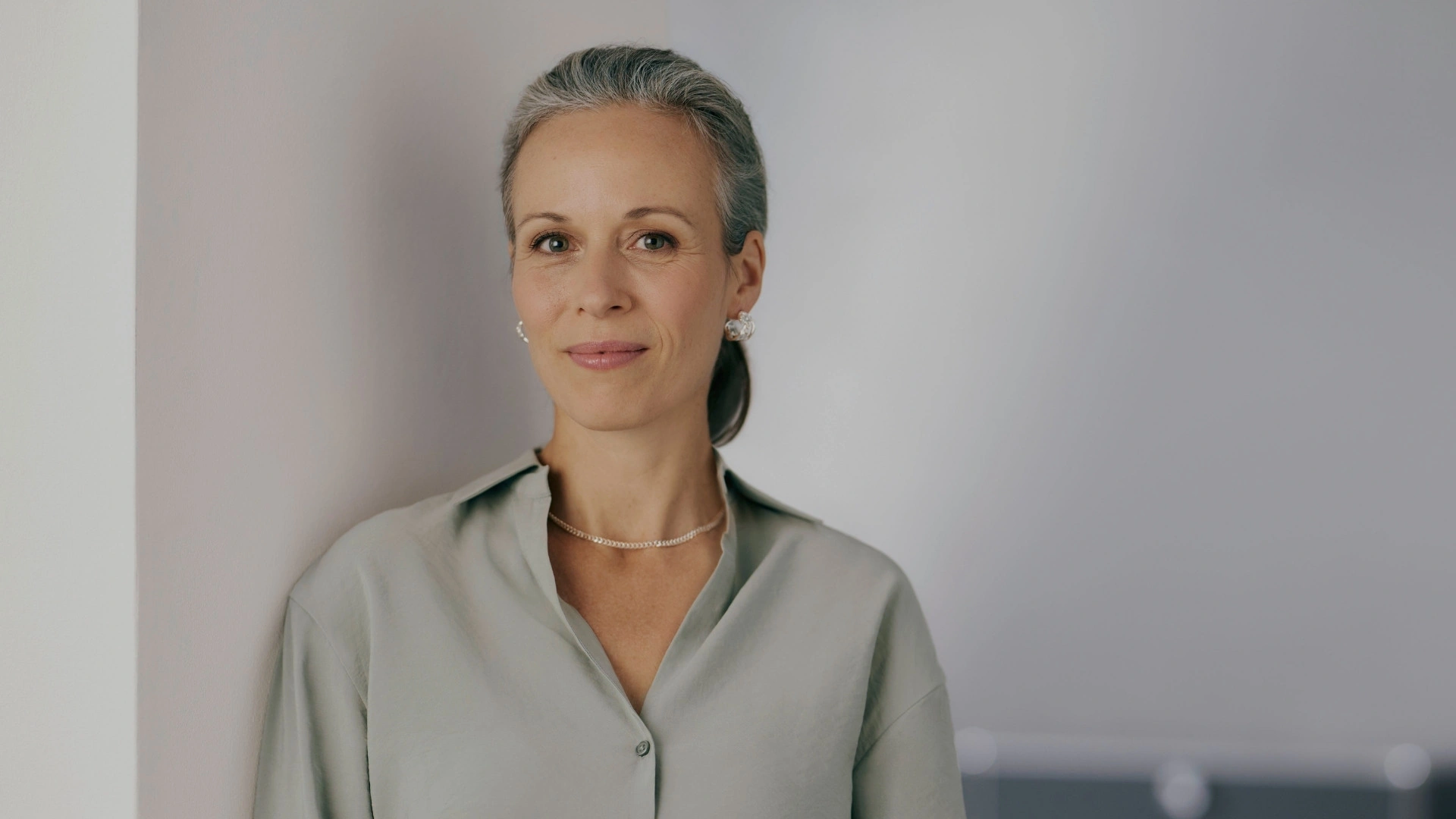 Portrait d’une femme expérimentée dans un environnement professionnel moderne. Elle incarne une décideuse du secteur financier qui fait avancer la digitalisation dans le banking grâce à un CRM pour banques et prestataires de services financiers intégrant les systèmes bancaires centraux de manière fluide.