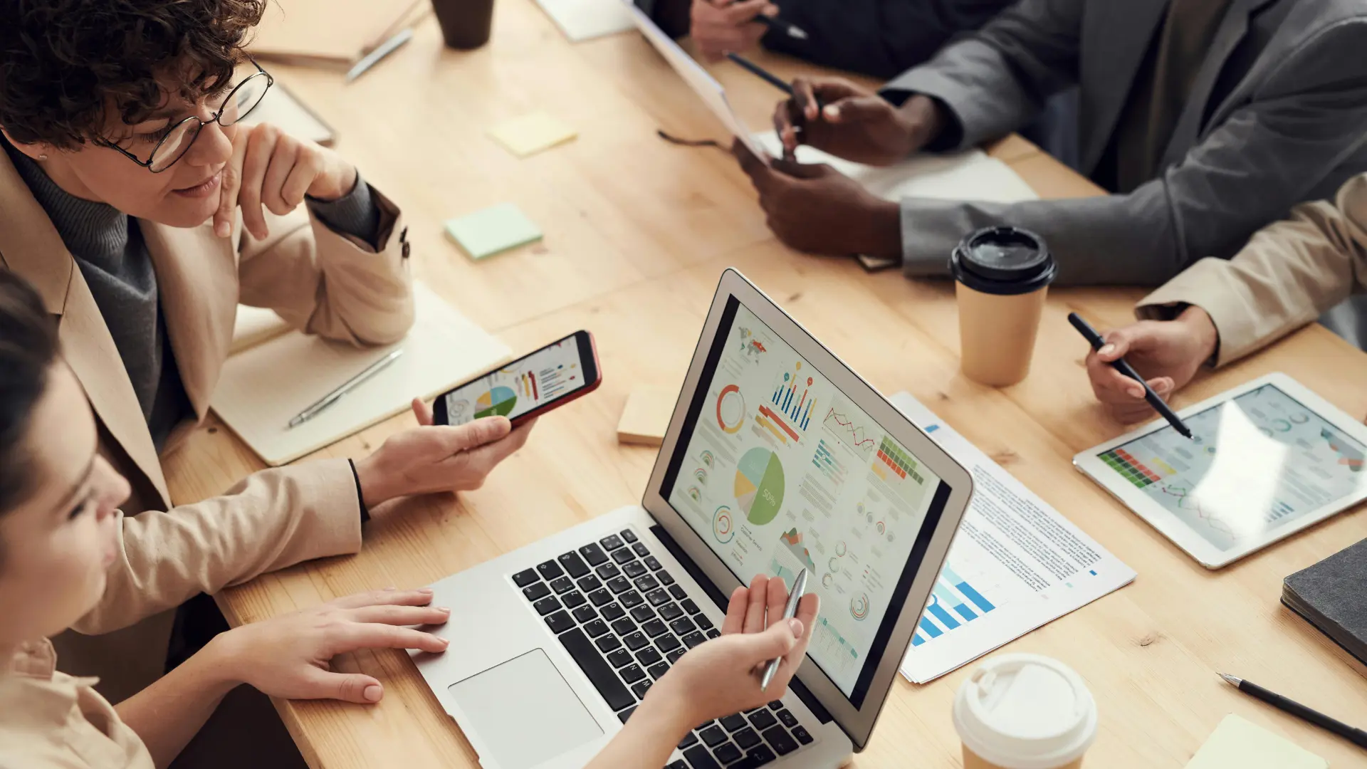 Team analyzes KPI dashboards and business data on laptop, tablet, and smartphone to define data-driven goals in customer relationship management and optimize business processes strategically. Source: fauxels@Pexels